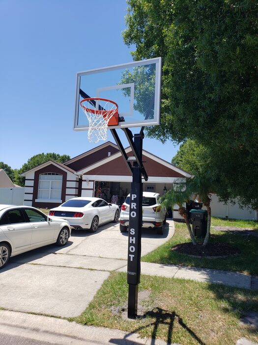 In-ground Pro Shot basketball pole installed in a front driveway