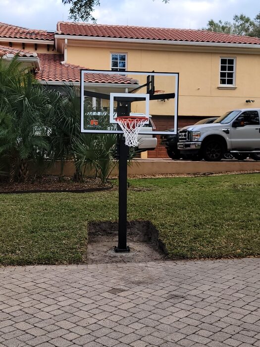 Goalrilla in-ground basketball hoop installed in front of a tile-roof Florida home