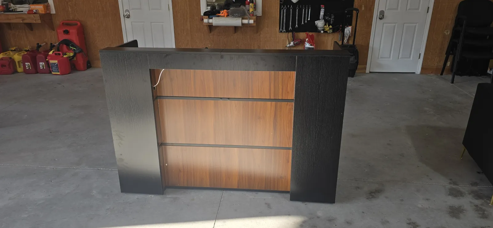 Black and walnut entertainment center media console assembled in a Florida garage