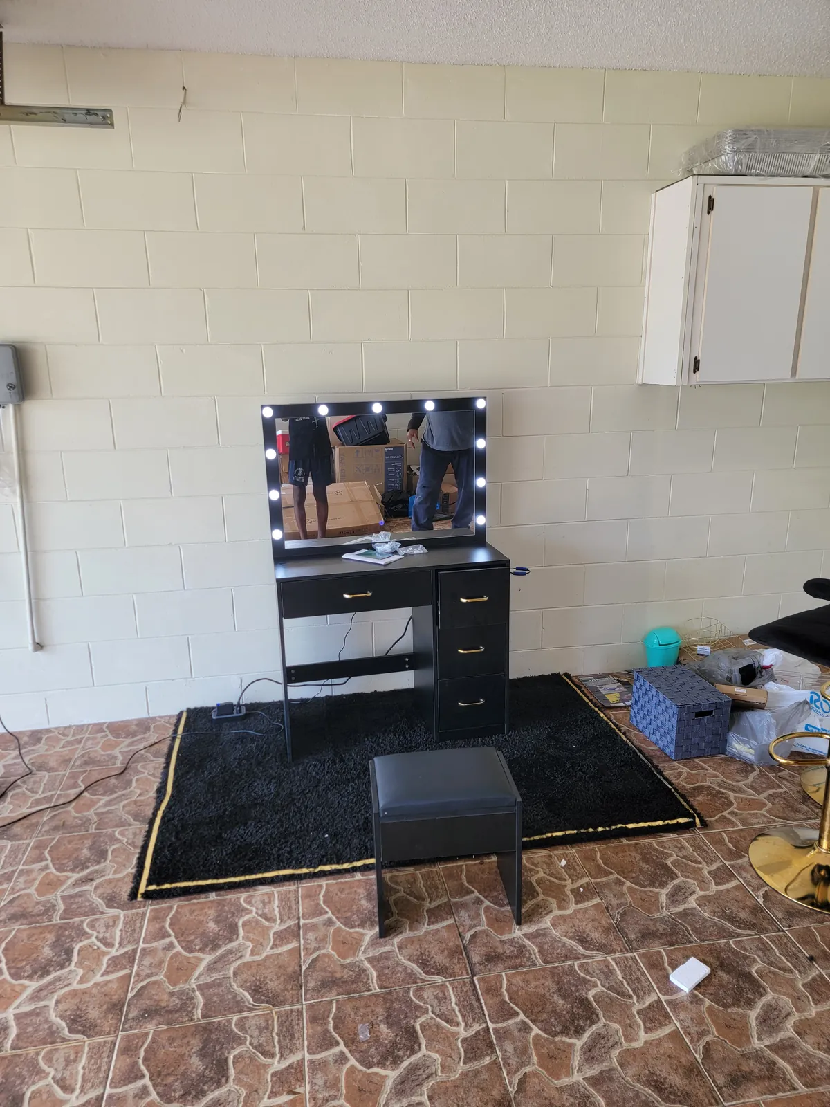 Black Hollywood makeup vanity desk with lighted LED mirror and stool assembled in a Florida home