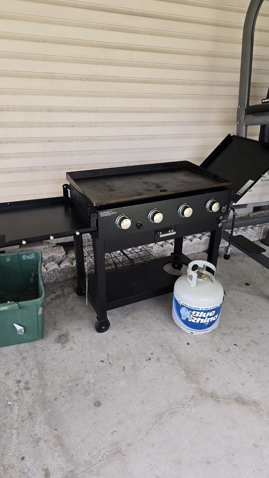 Four burner outdoor flat top griddle station assembled with propane tank on a covered patio in Florida