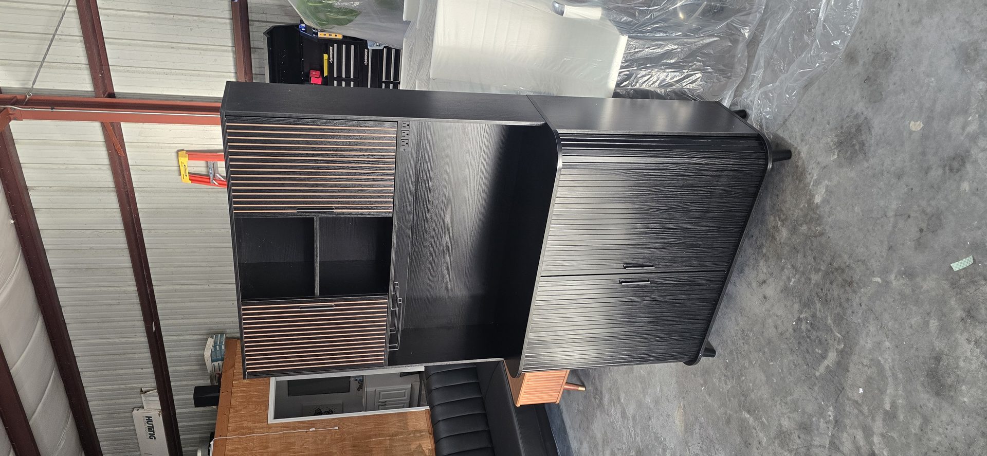 Dark entertainment center cabinet with slatted doors assembled by DR Assembly in warehouse