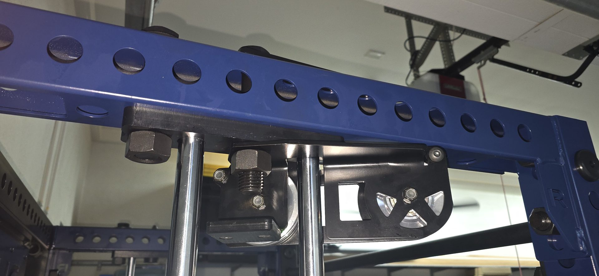 Detail shot of Rogue FM-3 Indy pulley assembly showing bolt hardware and steel crossmember hole pattern