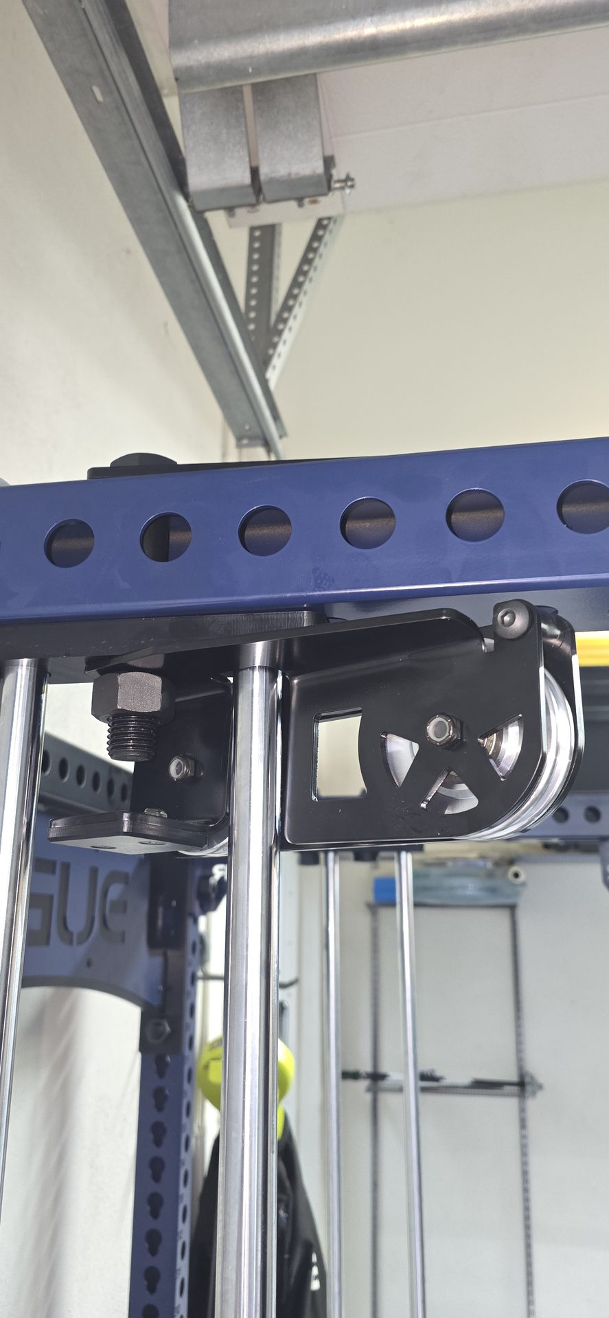 Close-up of Rogue FM-3 Indy top pulley bracket mounted on blue steel crossmember with chrome guide rods