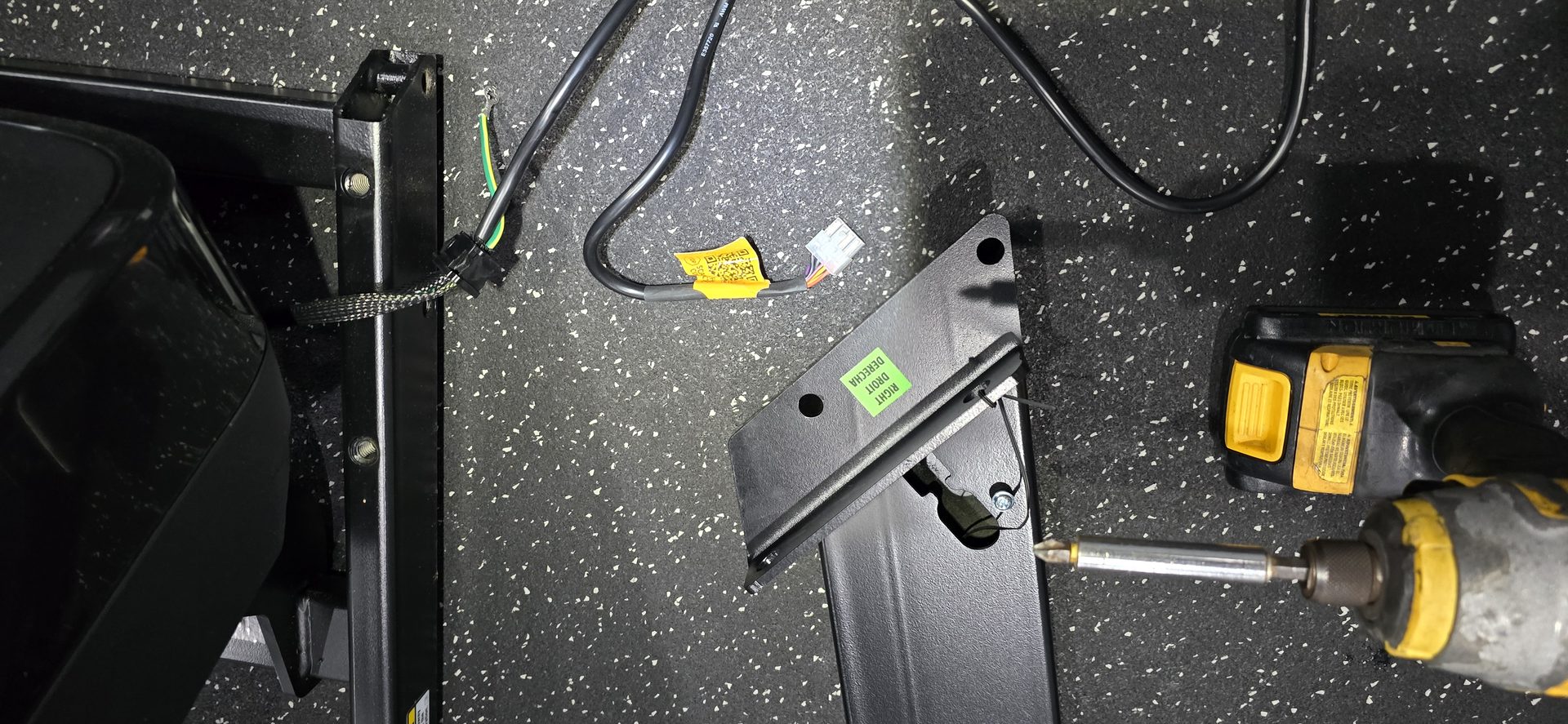 DR Assembly technician routing a treadmill console cable up the upright support leg on a real job